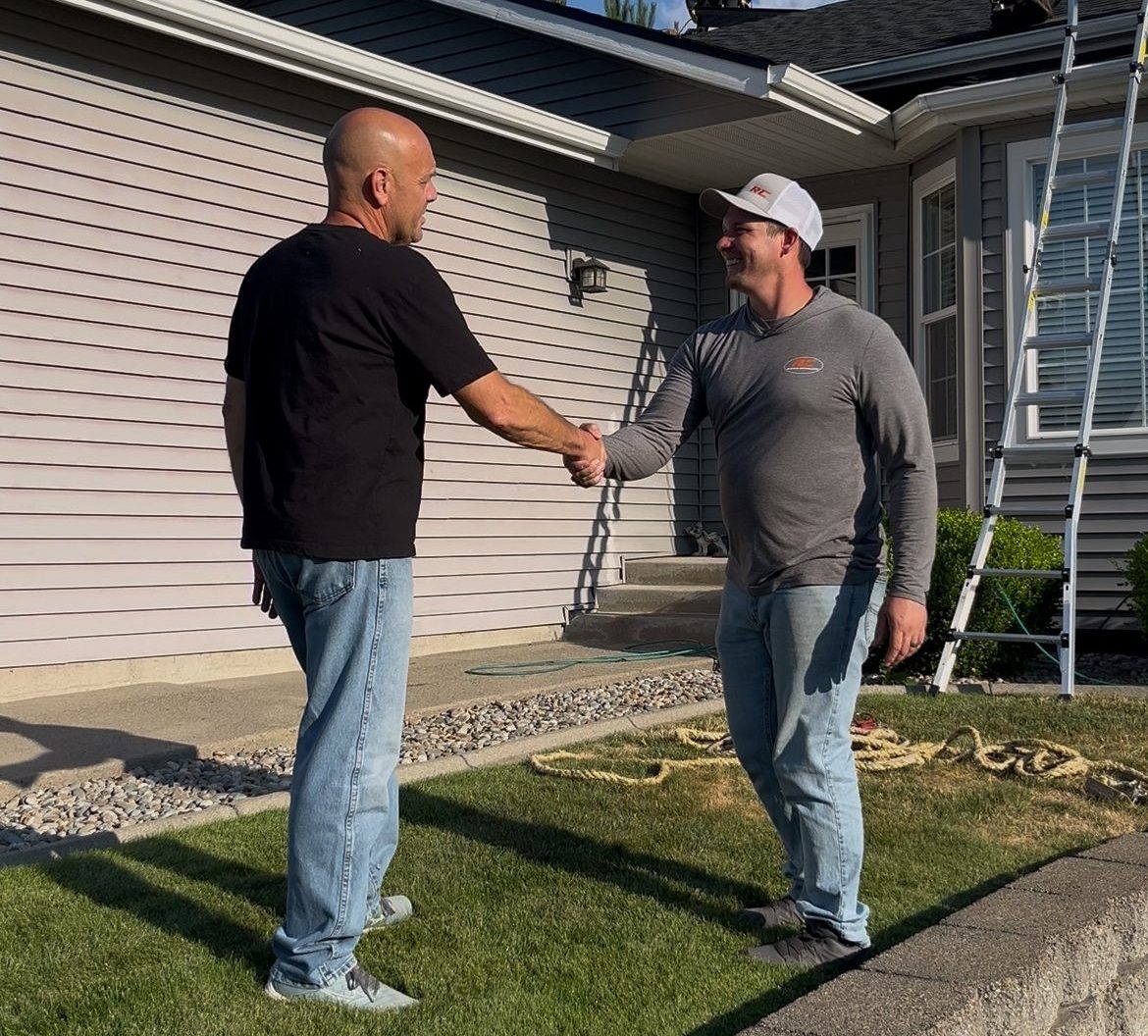 Josh owner of RC Roofing Shaking happy roof replacement customers hand