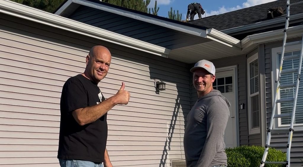 Happy RC Roofing Specialists roof replacement customer smiles at the camera with Josh